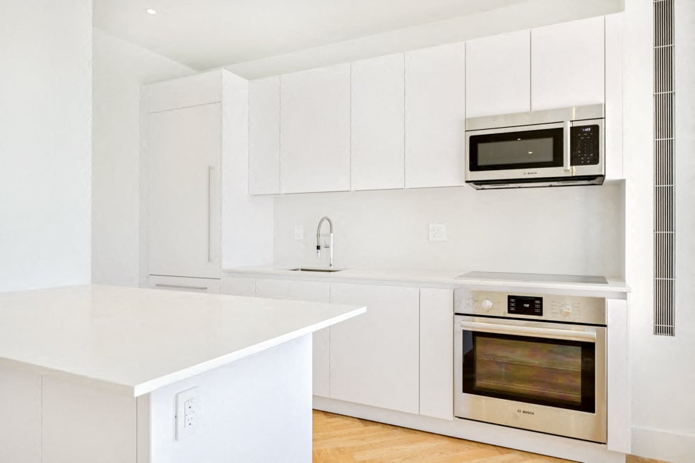 a kitchen with white cabinets and stainless steel appliances